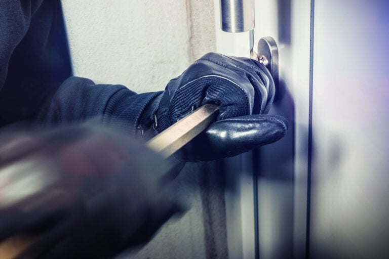 A burglary taking place, the door being pried open with a crowbar